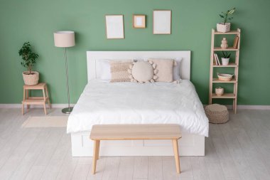 Yatak, raf ünitesi ve boş çerçeveli şık bir oda.