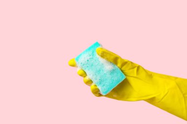 Pembe arka planı temizlemek için kauçuk eldiven tutuyordu.