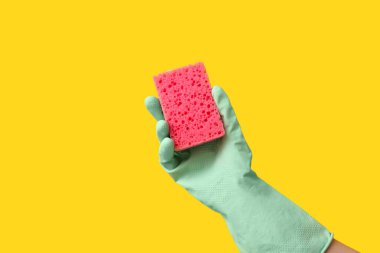 Sarı arka planı temizlemek için kauçuk eldiven tutuyordu.