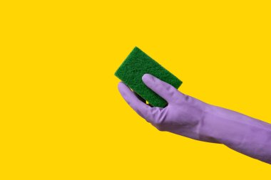 Sarı arka planı temizlemek için kauçuk eldiven tutuyordu.