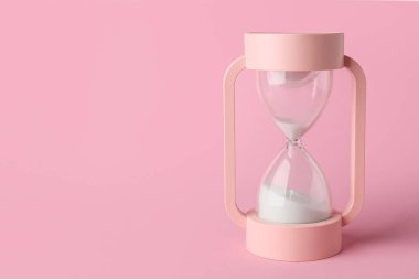 Pembe arka planda kristal kum saati