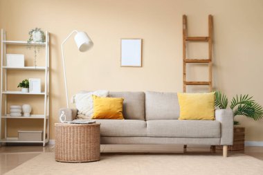 Modern oturma odasındaki yeni kanepe ve hasır masa.