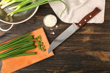 Ahşap zemin üzerinde taze yeşil soğan olan tahta.