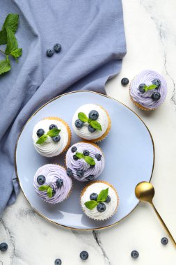 Beyaz arka planda yaban mersinli ve nane şekerli bir tabak lezzetli kek.