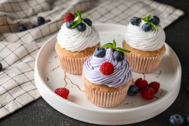 Böğürtlenli, ahudutlu ve siyah arkaplanlı lezzetli çörekler.