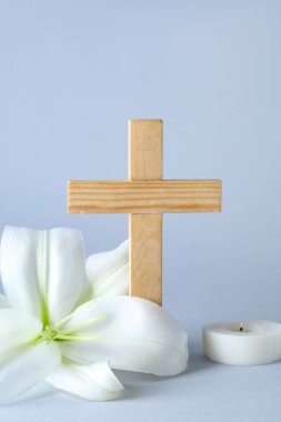 Güzel zambak çiçeği ve gri arka planda haç