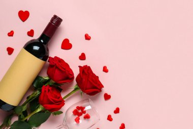 Bottle of wine with red roses and glass on pink background. Valentine's Day celebration