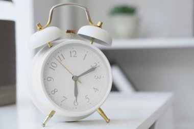 Ofisteki beyaz alarmlı saat, yakın plan.