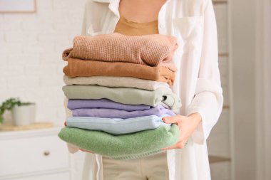 Evde şık giysileri olan genç bir kadın, yakın plan.