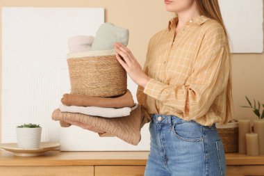 Hasır sepeti ve temiz giysileri olan genç bir kadın.