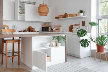 Masası, tezgahı ve dolabı olan modern mutfağın içi.