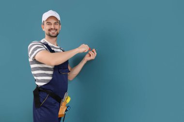 Erkek teknisyen mavi duvarı beceriyor.