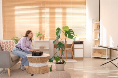 Modern projektörü olan genç bir kadın şık oturma odasındaki sehpanın üzerinde.