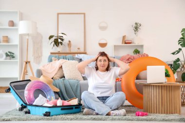 Stresli genç kadın eve gitmek için bavul hazırlıyor.