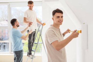 Odasında paten boyama duvarı olan genç bir adam.