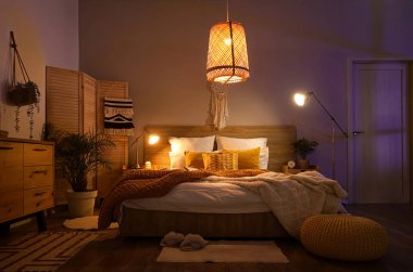 Koyu renk yatak odasının içinde katlanan ekran, bitkiler ve parlayan lambalar.