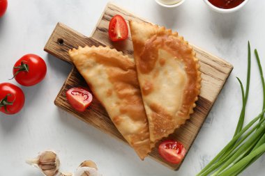 Lezzetli çizburgerler ve beyaz grunge masasında taze sebzeler.