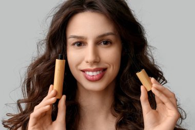 Gri arka planda maskarası olan güzel bir genç kadın.