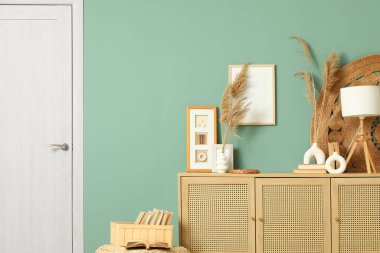 Çimenli vazolar, lamba ve fotoğraf çerçeveleri oturma odasındaki çekmecelerde, yakın plan.