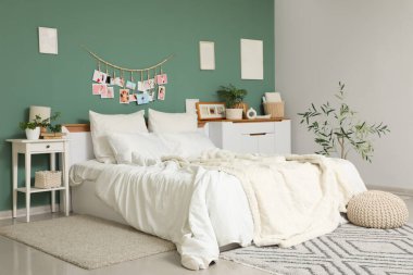 Yatak odasının içi, büyük rahat yatak odası, puf ve çekmeceler yeşil duvarın yanında.