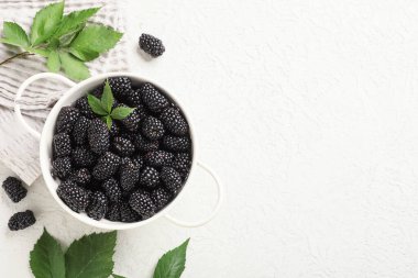 Olgun böğürtlenli kompozisyon ve beyaz grunge arka planda yapraklar, yakın plan