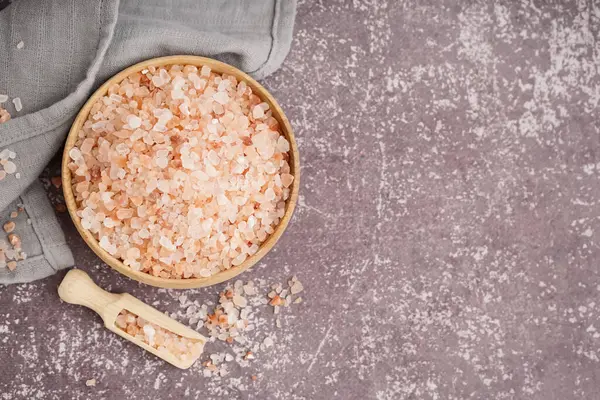 Tahta kase ve kepçe ile Himalaya pembe tuzu karanlık masa üzerinde