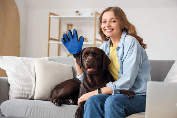 Young woman with pet glove and her cute dog at home