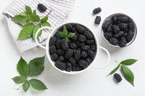 Olgun böğürtlenli kompozisyon ve beyaz grunge arka planda yapraklar, yakın plan