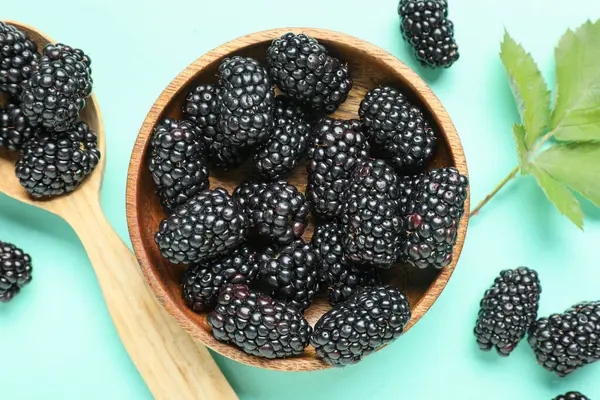 Turkuaz arka planda olgun böğürtlenli kase, yakın plan.