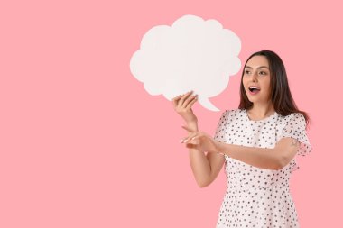 Boş konuşma balonu olan genç bir kadın pembe arka plandaki bir şeyi işaret ediyor.
