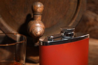 Ahşap arka planda yeni cep şişesi ve cam, yakın plan.