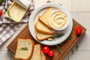 Ahşap tahta tahta tahta tahta kutular dolusu işlenmiş peynir, kızarmış ekmek ve sebzeler beyaz karo arka planda.