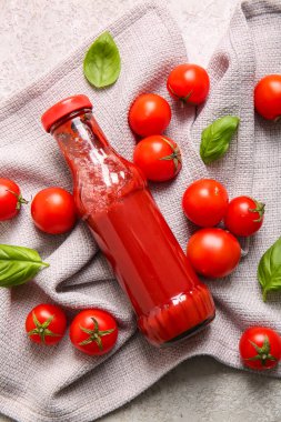 Beyaz arka planda bir şişe ketçap ve domates.