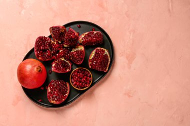 Pembe arka planda taze nar tabağı.