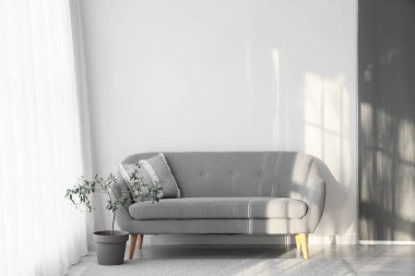 Işık perdesi ve kanepesi olan oturma odasının içinde.