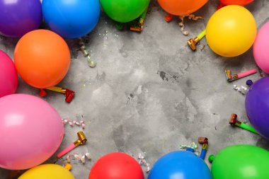 Gri arkaplanda neşeli balonlardan ve ses çıkaranlardan yapılmış çerçeve