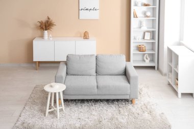 Kanepesi, masası ve raf ünitesi olan modern oturma odasının şık bir iç mekanı.