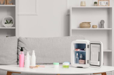 Oturma odasındaki ürünlerle birlikte kozmetik buzdolabını aç