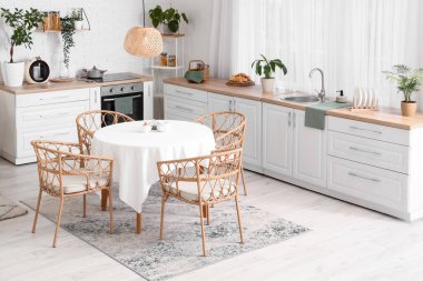 Beyaz tezgahlı ve yemek masalı mutfağın içi.