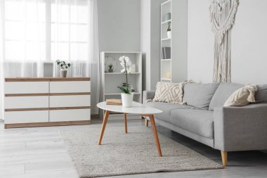 Oturma odasının içinde kanepe ve masa var.