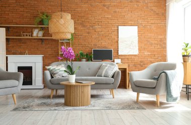 Masasında kanepe, koltuk ve orkide olan bir oturma odası.