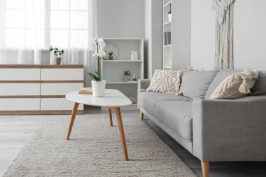 Oturma odasının içinde kanepe ve masa var.