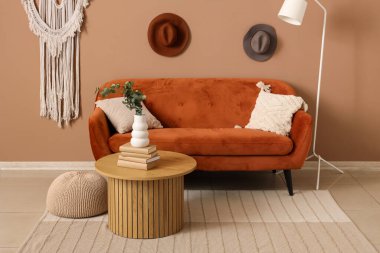 İçinde kanepe, masa ve vazoda yapay okaliptüs olan şık bir oturma odası.