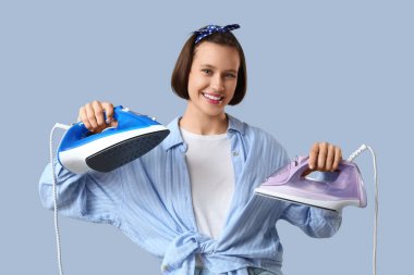 Gri arka planda ütüler ile genç kadın