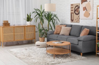 Rahat kanepesi, sehpası ve çiçekli modern bir oda.