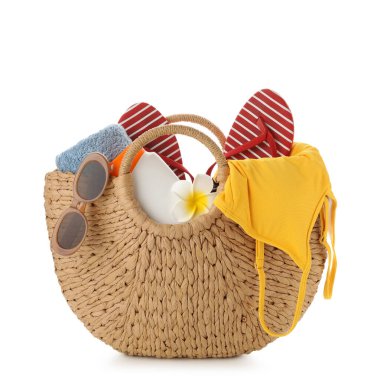 Beyaz arka planda güneş kremi, mayo ve plaj aksesuarları olan bir çanta.