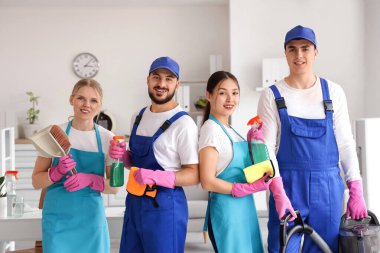 Ofisinde temizlik malzemesi olan bir grup hademe.