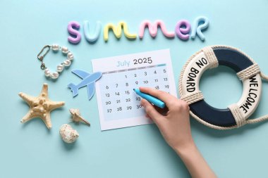 İşaretli kadın eli, takvim ve mavi arka planda plaj dekoru. Yaz tatili kavramı