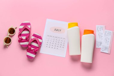 Güneş kremli takvim, biletler ve pembe arka planda parmak arası terlikler. Yaz tatili kavramı