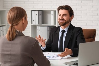 Genç işadamı ofiste meslektaşıyla konuşuyor.